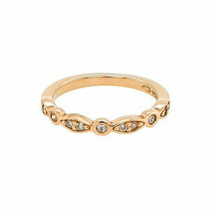 A rose gold ring with five marquise-shaped and two round diamonds in a shared prong setting
