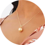 A women wearing gold necklace with a pearl pendant
